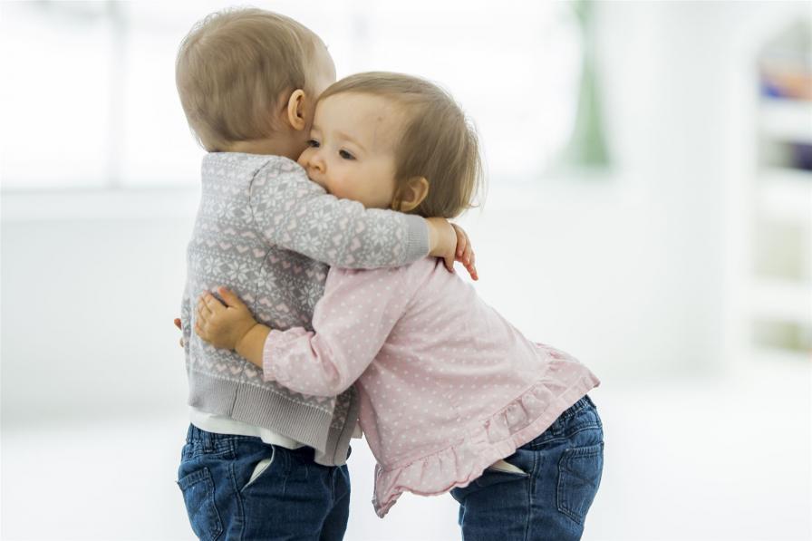 Zwei kleine Kinder umarmen sich